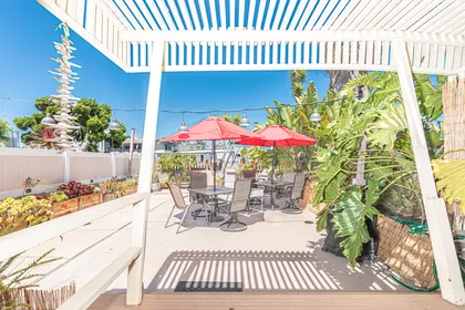 The large private rear patio includes 2 dining tables (each w/ seating for 4), side seating, market umbrella, propane gas bbq grill, and access to small boat dock.