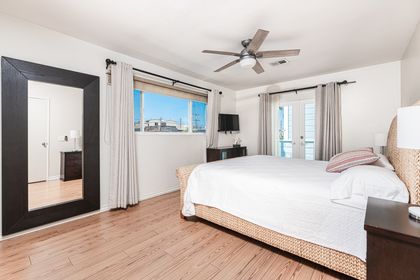 Bedroom 1 of 3 is located on the second floor of the main house and includes a king bed, TV, French doors that lead to the rooftop deck and an en-suite bathroom with an open design.