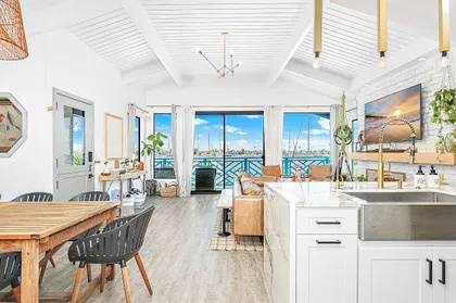 Open dining, kitchen, and living areas with bay views