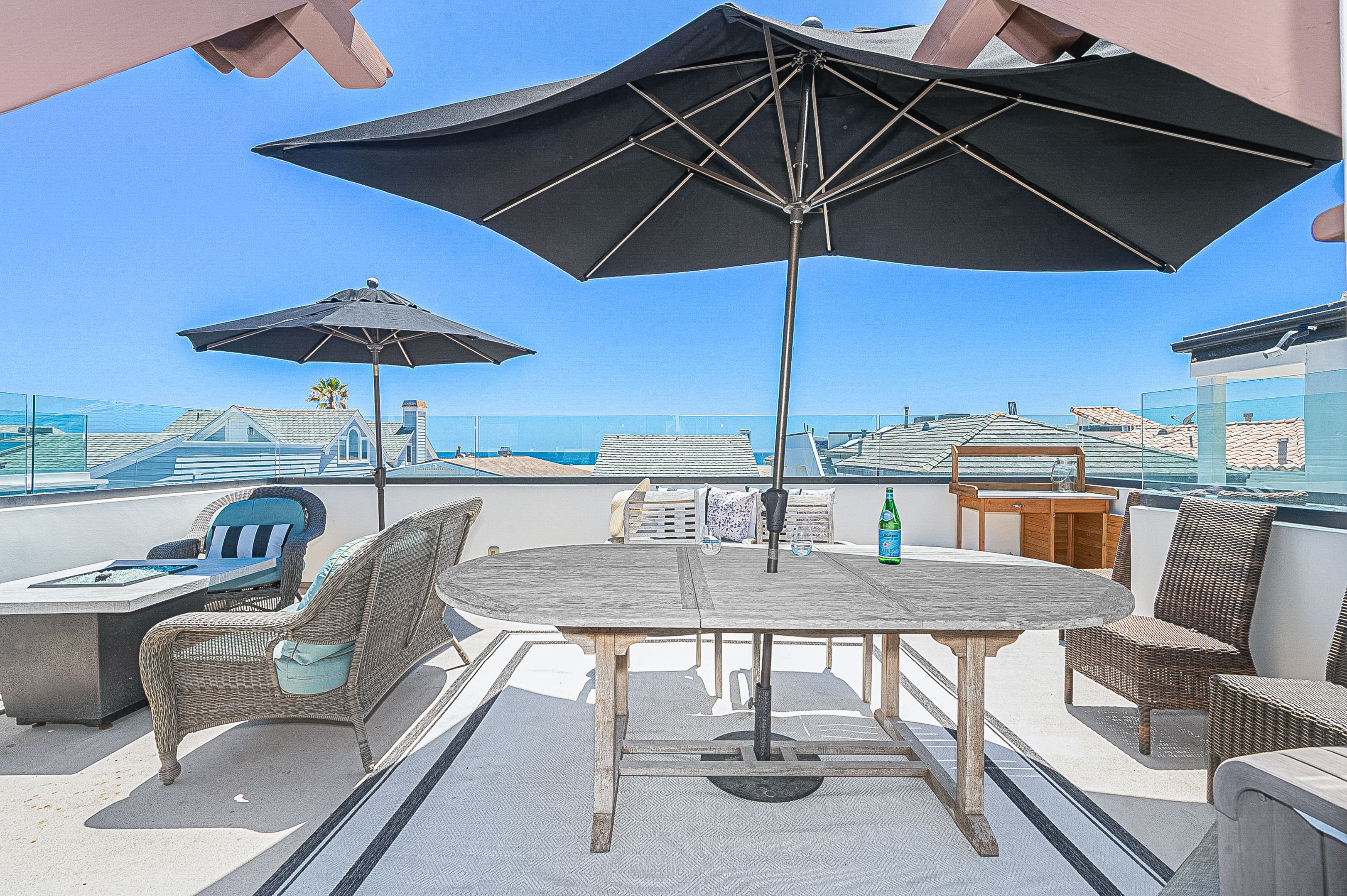 The rooftop deck includes ample seating, a large dining area, market umbrellas, propane gas BBQ grill, and ocean view make this the perfect hangout spot.