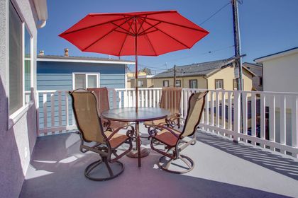 Private rear balcony with outdoor seating and umbrella to enjoy the morning sunshine with a cup of coffee. Accessed from Bedroom #4 sliding glass door.