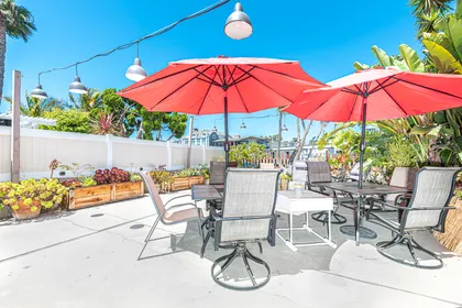 This two-story, single-family home is tucked away in its own bayside garden oasis on one of Newport Harbor’s side channels.