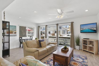 Living and dining areas look out to front ocean view patio, with easy access through sliding glass doors. Ceiling fans throughout.