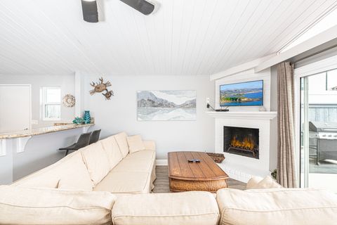 The living area includes sofa, cable TV,  dining table with seating for 6, and kitchen beyond.