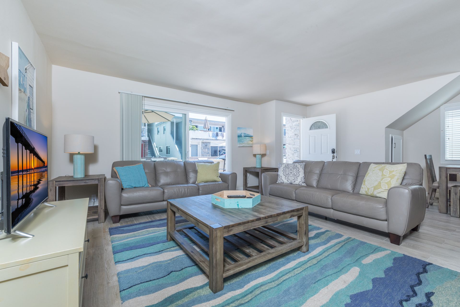 Spacious living room looks out to front ocean view patio, with easy access through sliding glass doors.