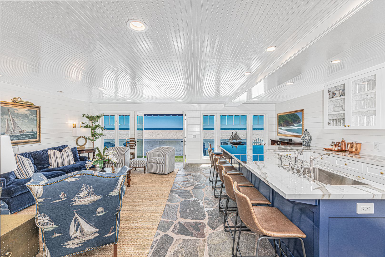 Bright open-concept living and kitchen area with ocean views and coastal-inspired décor