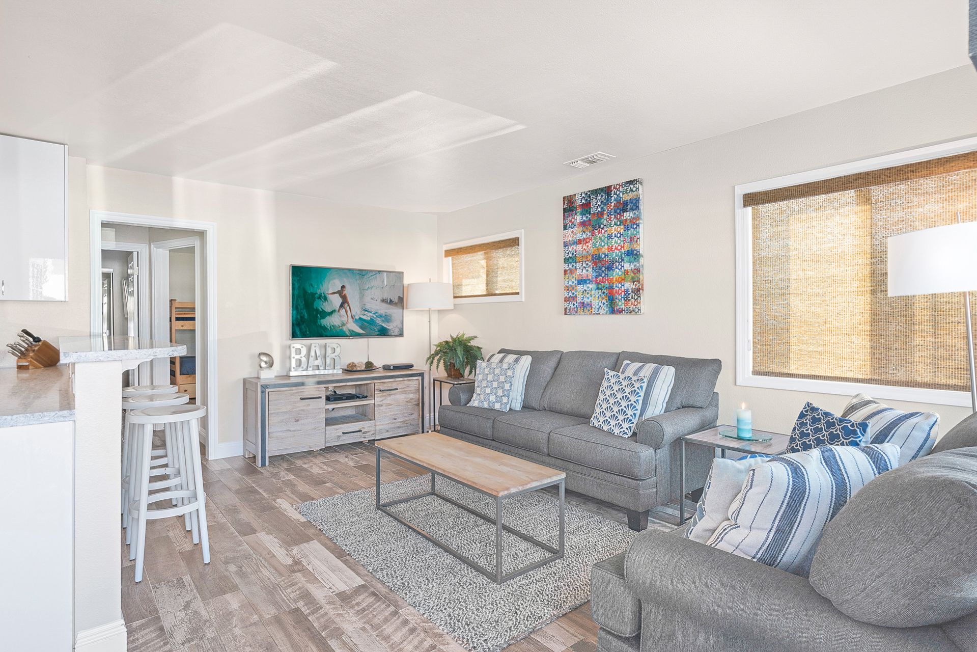 Roku TV, couch, and love seat open up to the bar seating area and kitchen.