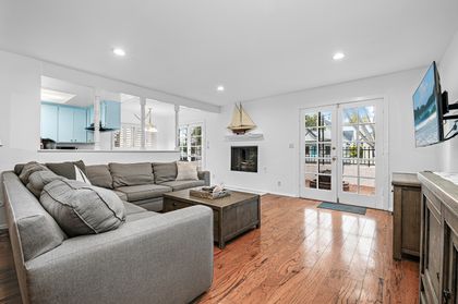 A welcoming living space featuring a spacious sectional, fireplace, and TV