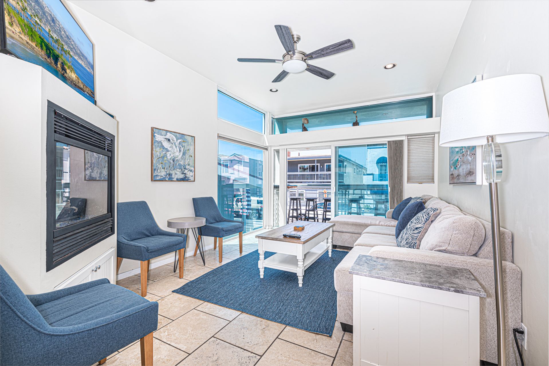 Main living area, located on the middle level includes seating, fireplace, TV, ceiling fan and sliding glass door to front ocean view balcony.
