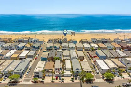 Aerial view highlighting the prime oceanfront location of this Newport Beach property, right on the sand and surf