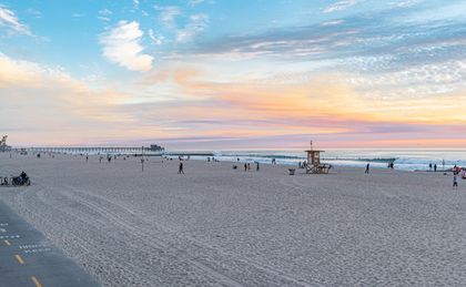 View of the beach in front of your rental: soft sand, tame waves, and plenty of space to spread out and soak up the sun.