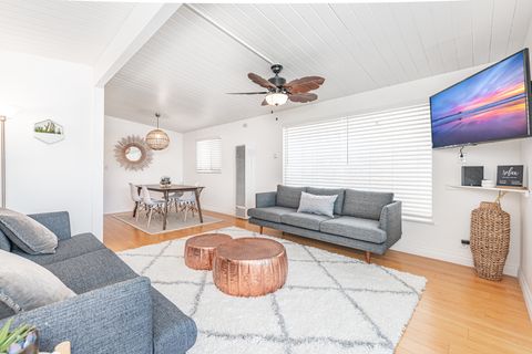 The main living area features a sofa set, streaming TV, and a dining table with seating for four.