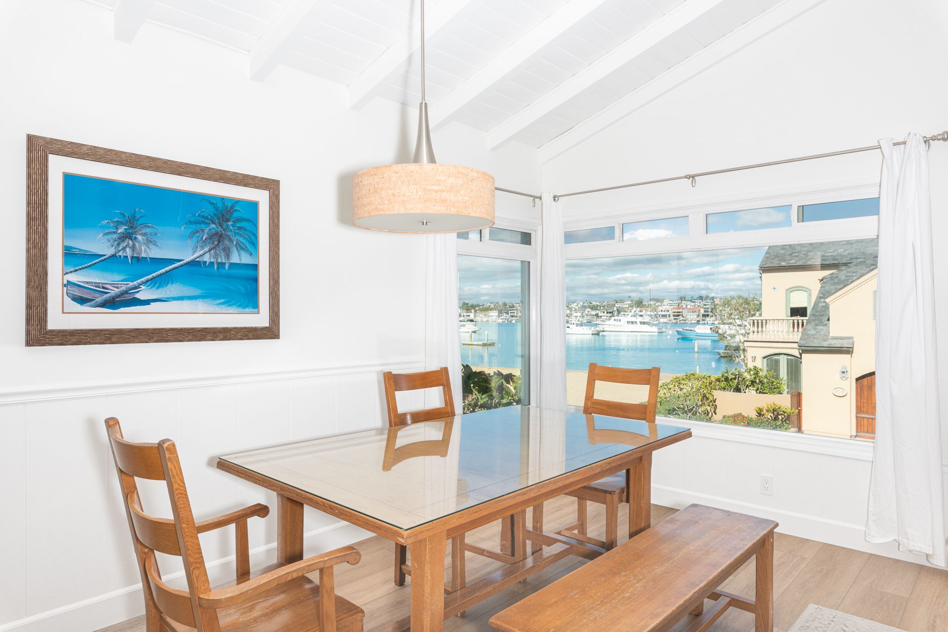 A bright dining room with comfortable seating, perfectly positioned to enjoy meals with picturesque bay views
