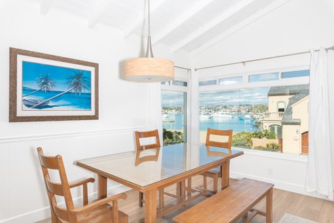 A bright dining room with comfortable seating, perfectly positioned to enjoy meals with picturesque bay views