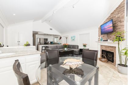One of two living rooms in the rental, this second level living area includes a large sofa, cable TV, dining table for four, wet bar station, and French doors that lead to your beachfront patio.