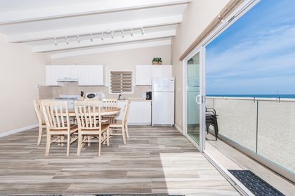 The kitchen stretched along the wall beyond the dining area and is stocked with dishes, utensils, cookware, bakeware, and large and small appliances.