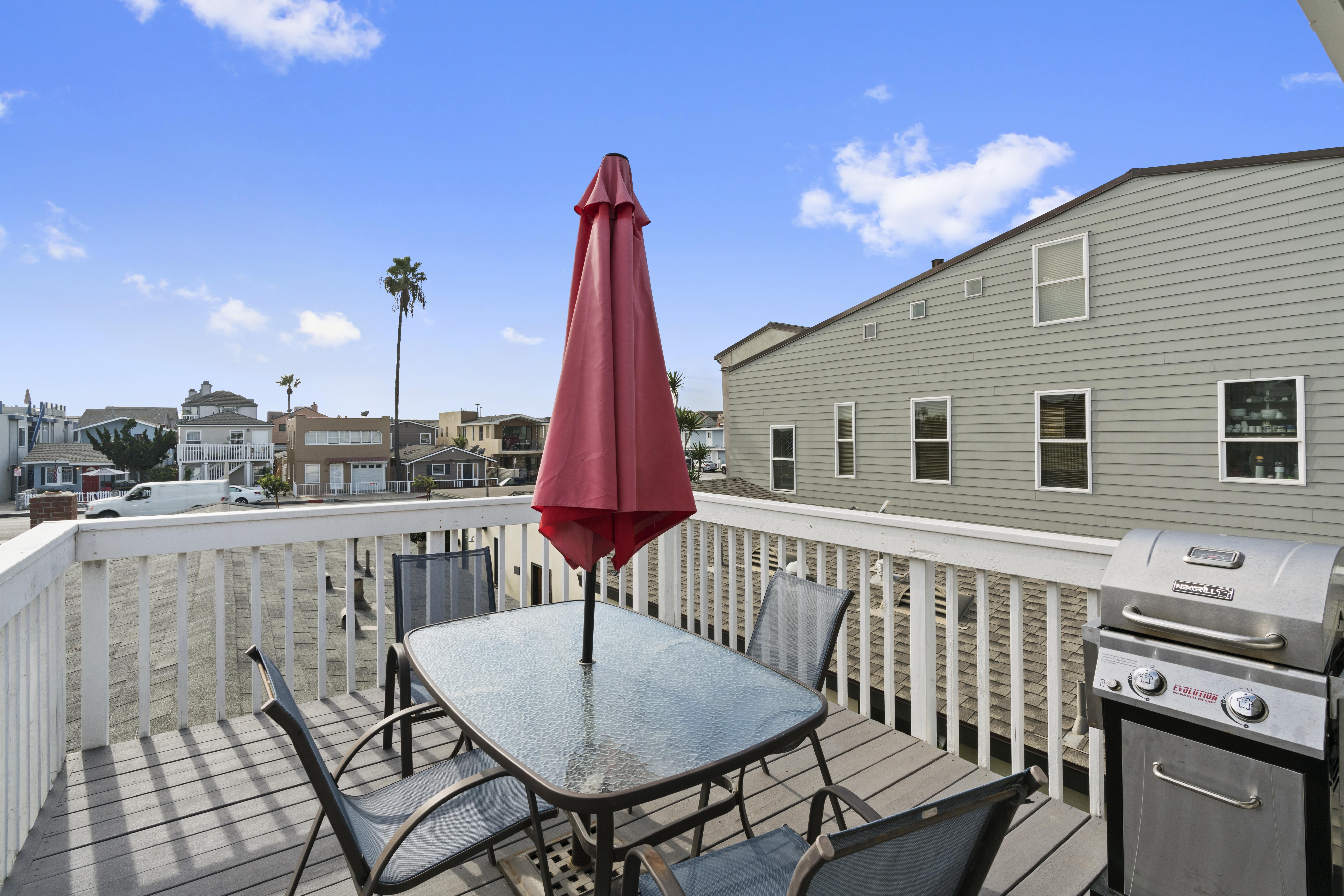 The front outdoor deck includes seating for four, market umbrella, and a propane BBQ grill.