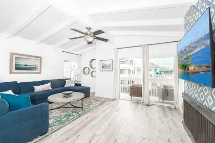 The bright and cheery living area includes a large U-shaped sectional sofa and streaming TV.