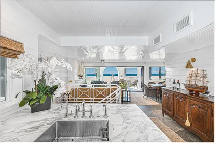 Elegant kitchen featuring marble countertops and panoramic beachfront windows