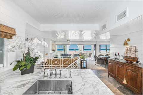 Elegant kitchen featuring marble countertops and panoramic beachfront windows