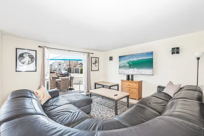 Living room looks out to front ocean view patio, with easy access through sliding glass doors.