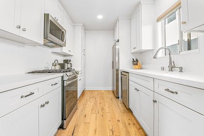 Bright white galley kitchen with sleek stainless steel appliances