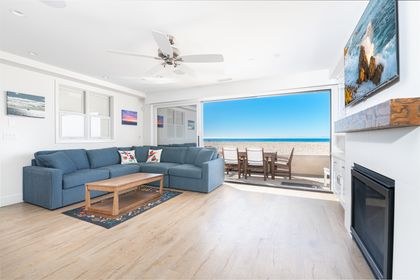A bright living space where the ocean becomes part of the room, slide open the doors, unwind by the fireplace, and let the sea breeze in