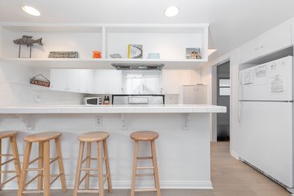 A pantry area is located beyond the refrigerator, with entry door to and from exterior side walkway.