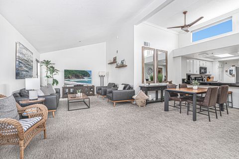 The living area includes sofa, side chairs, streaming tv, dining table with seating for 4, and kitchen beyond.