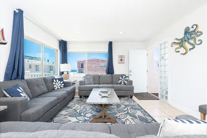 Drop your bags and enjoy a carefree, car-free vacation in this bright and cheery upstairs beach house, just one home from the sand!
