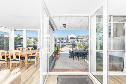 Patio doors out to the patio with a spacious cushioned seating area and private dock beyond. (Guests must supply their own kayaks and paddleboards. Boats are not permitted).