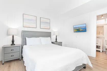 Serene primary suite with soft light, crisp linens and a private en-suite bathroom