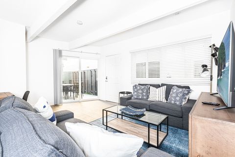 Clean with crisp white touches, the main living area features 2 sofas and a streaming TV.