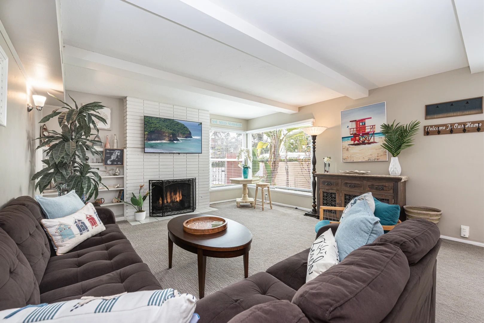 Bright and inviting living room with comfortable seating, coastal décor, and ample natural light, perfect for relaxing after a day at the beach