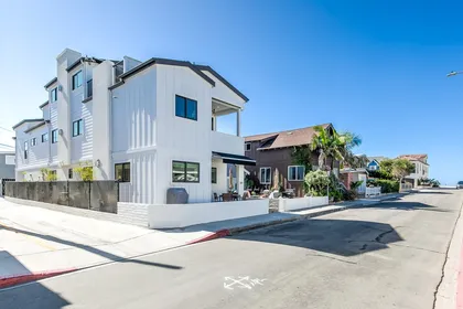 View of the home, just 7 houses from the sand! Covered parking is behind the home and accessed through the alleyway (pictured).
