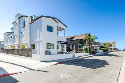 View of the home, just 7 houses from the sand! Covered parking is behind the home and accessed through the alleyway (pictured).