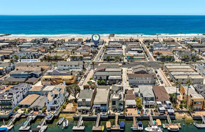 Bird’s-eye view of the Newport Beach Peninsula showcasing the vibrant beachfront and surrounding neighborhood.