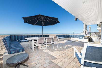 Dine al fresco just steps from the shoreline, this oceanfront patio offers a dining table for six with additional seating