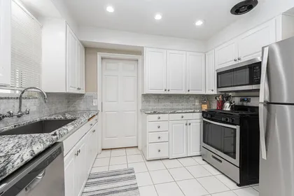 Updated kitchen with granite countertops, stainless steel appliances, and crisp white cabinetry for effortless cooking