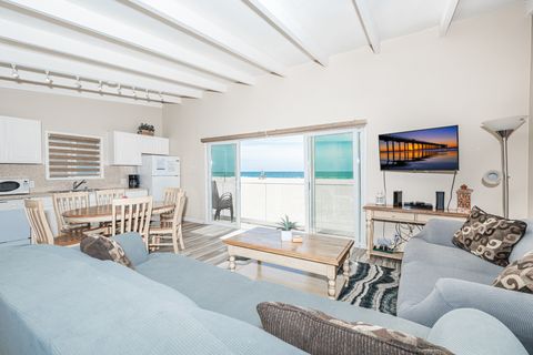 The main living area includes a sofa & loveseat set, cable TV, dining table for 4, and of course, an oceanfront view.