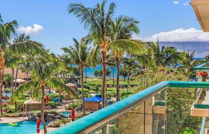 An expansive 2 bedroom with partial ocean views through the lush courtyard foliage