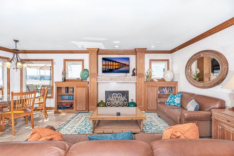 The main living area features a sofa (pullout), love-seat, gas log fireplace, and cable + streaming TV. It opens out to the dining area and kitchen.