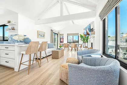 Relax in the airy living space with soaring ceilings, comfortable seating, and plenty of natural light for effortless coastal living