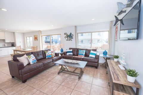 The main living area includes a sofa set, cable TV, and sliding glass doors that open up to the expansive front patio.