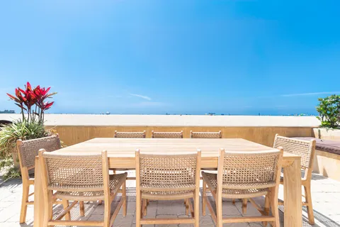 Enjoy oceanfront dining for eight with wide-open views across the sand and Pacific