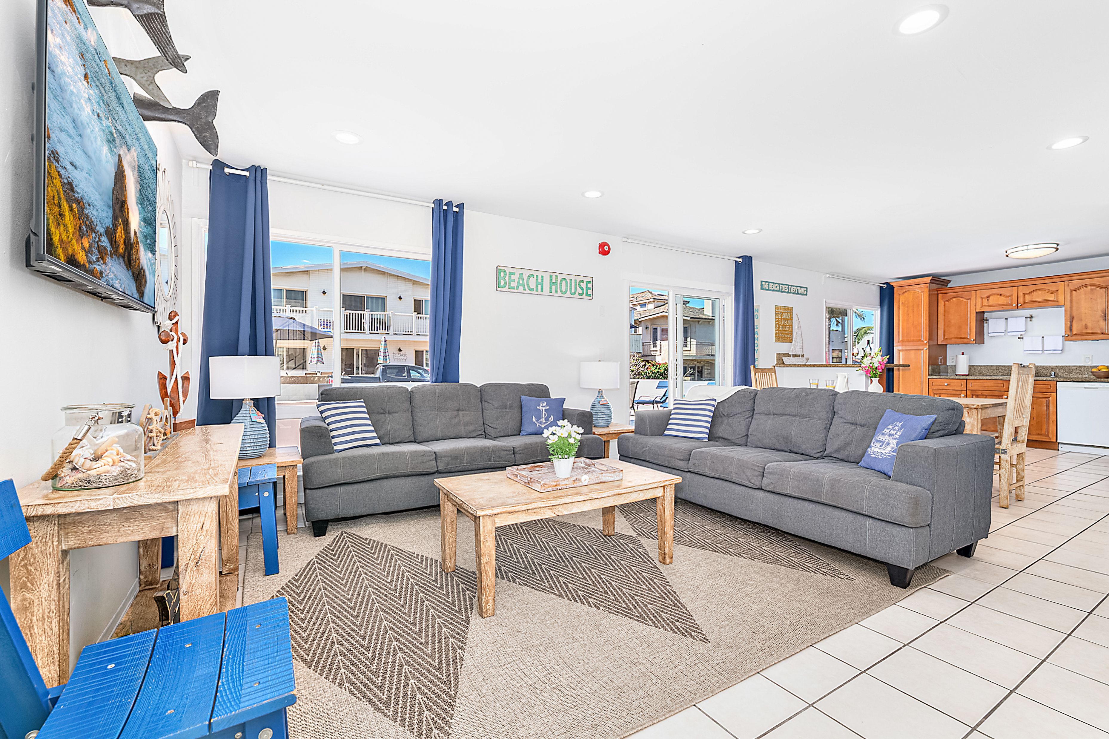 The main living area includes a sofa set, cable TV, and a sliding glass door that opens to the front patio