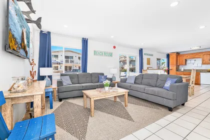 The main living area includes a sofa set, cable TV, and a sliding glass door that opens to the front patio