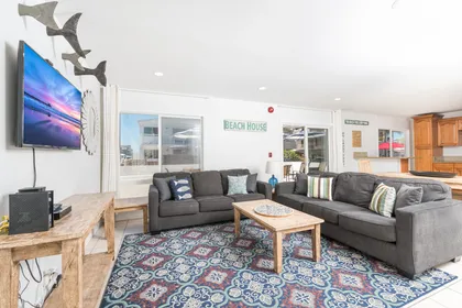 The main living area includes a sofa set, cable TV, and a sliding glass door that opens to the front patio