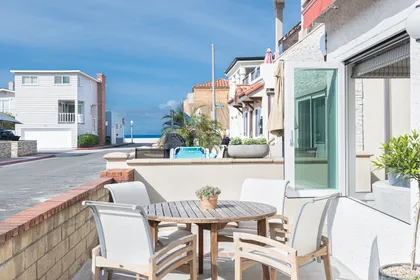 Inviting front patio with comfortable seating and peek-a-boo ocean views along a coveted Newport Beach street.