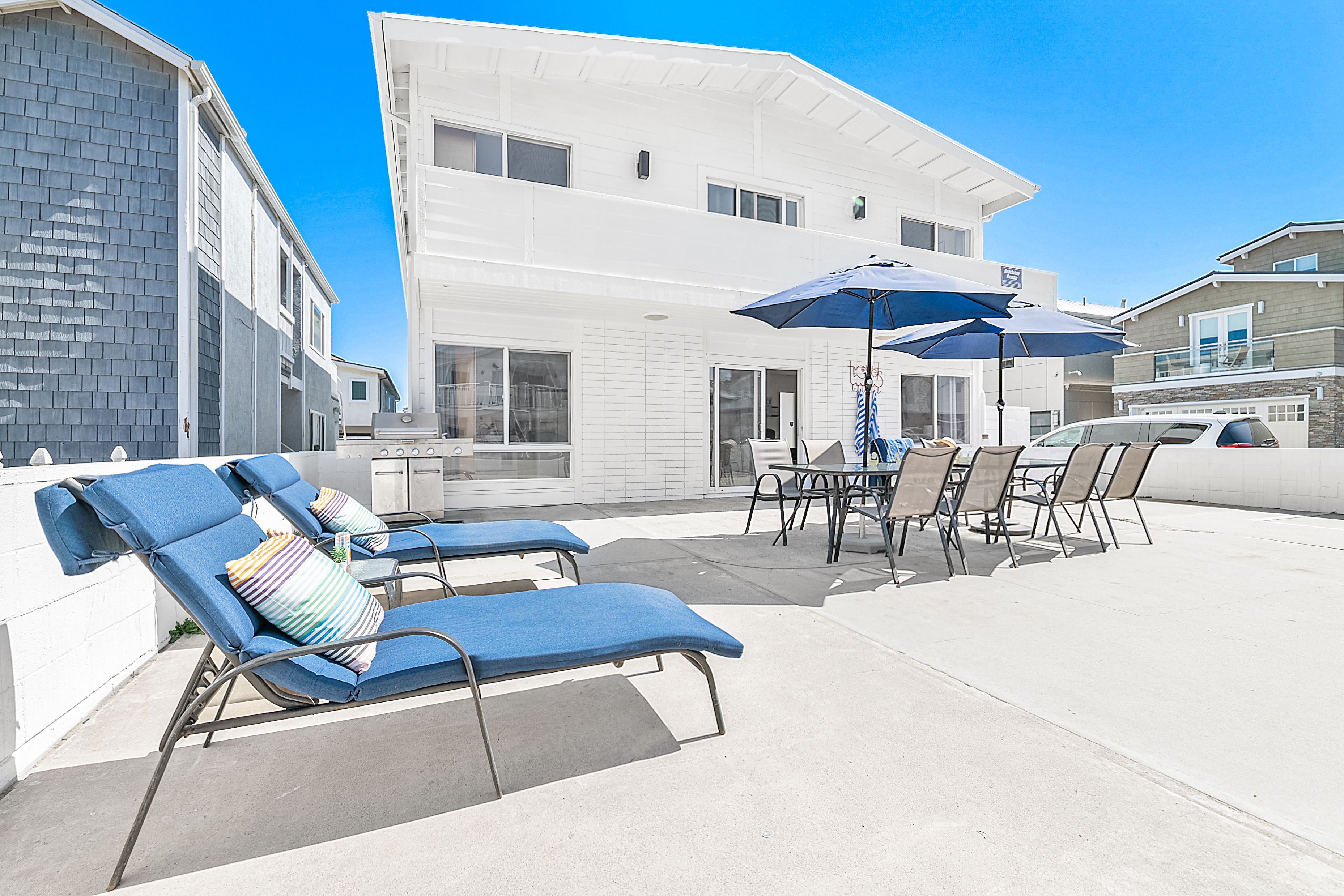 This home's oversized patio includes lounge chairs, two market umbrellas, and outdoor tables and chairs